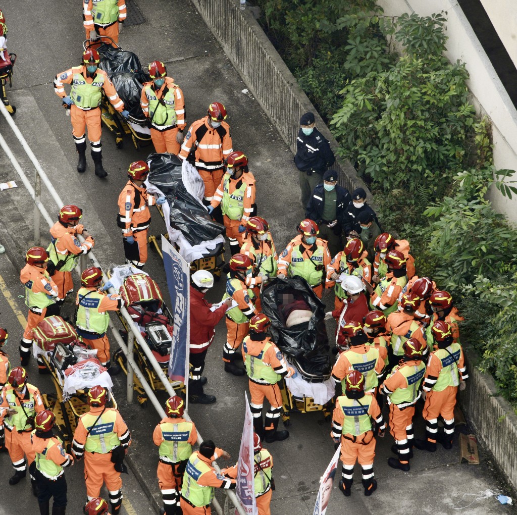 消防在火場抬出三具屍體。陳浩元攝 消防在火場抬出三具屍體。陳浩元攝