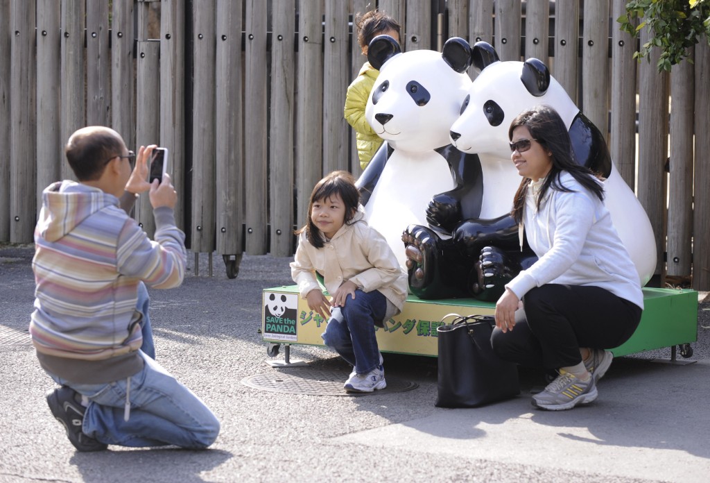 遊客在上野動物園與大熊貓模型合影。（新華社）