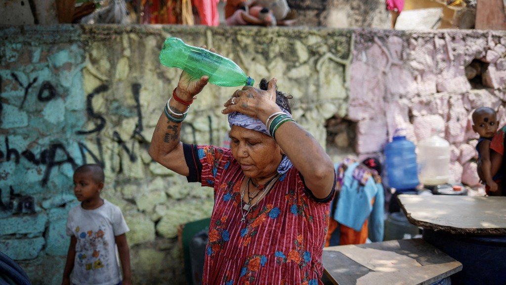 新德里一名女子用水淋頭降溫。 路透社