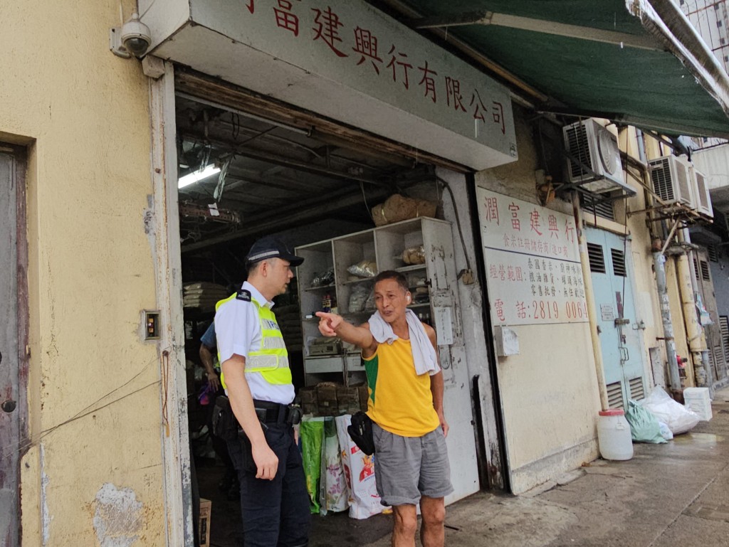 警员向附近商铺询问案发经过。