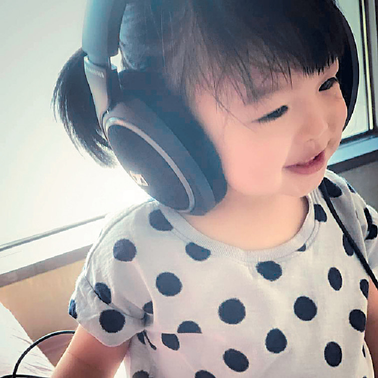 爸爸歌聲■兩歲小豬比戴住headphone聽爸爸唱歌，笑得好開心。