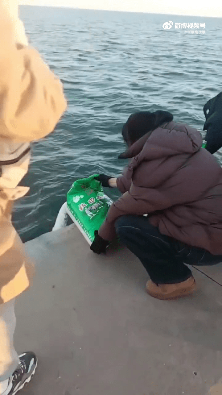 遼寧葫蘆島多人海邊「倒米」,口中唸唸有詞。 遼寧葫蘆島多人海邊「倒米」,口中唸唸有詞。