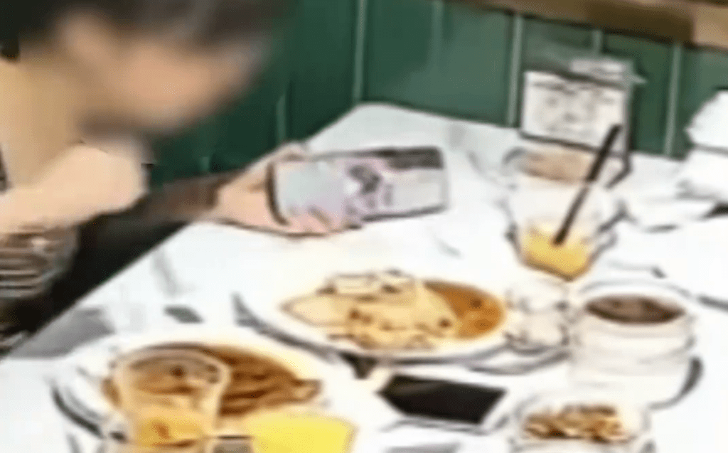女食客用手机拍摄申请退款。