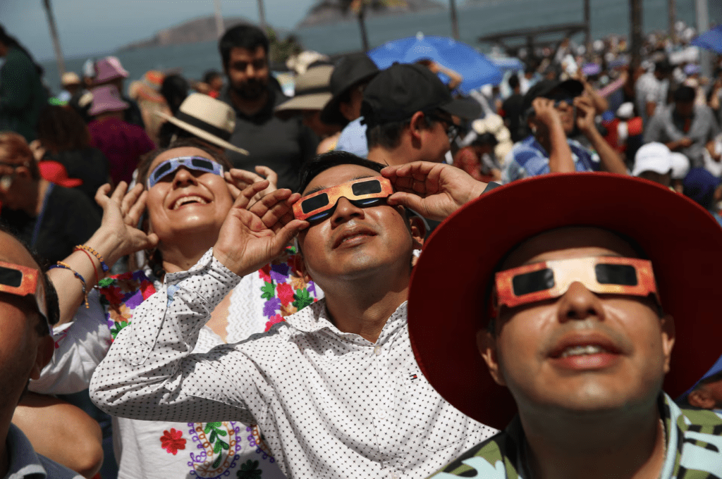 2024 年 4 月 8 日，墨西哥馬薩特蘭，人們使用特殊防護眼鏡觀察日全食。路透社