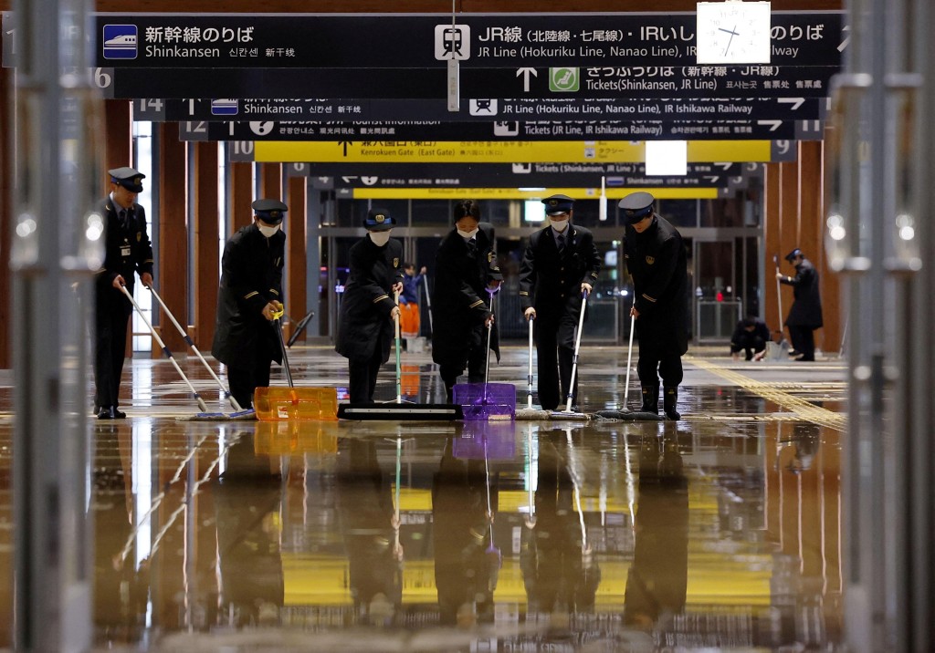 金澤火車站漏水，工作人員清理積水。美聯社