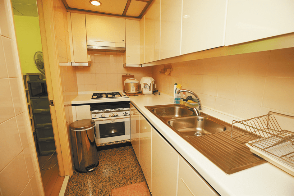 廚房L字形設計，廚櫃及基本家電齊全。