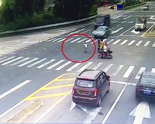 女子騎電動車闖紅燈， 兒子忽跳落車橫衝馬路。(網圖)
