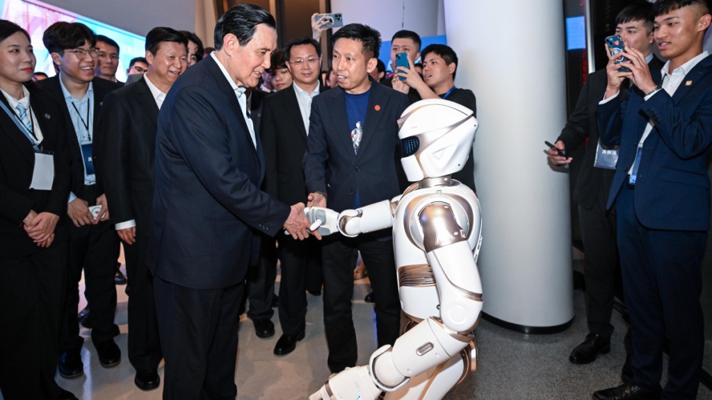马英九在深圳平安金融中心云际观光层与机器人握手。新华社