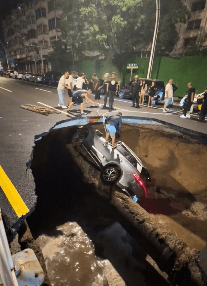 河北張家口路面深夜塌陷,3車墜落致1死1傷,市民用繩索協助拉救被困者。 河北張家口路面深夜塌陷,3車墜落致1死1傷,市民用繩索協助拉救被困者。
