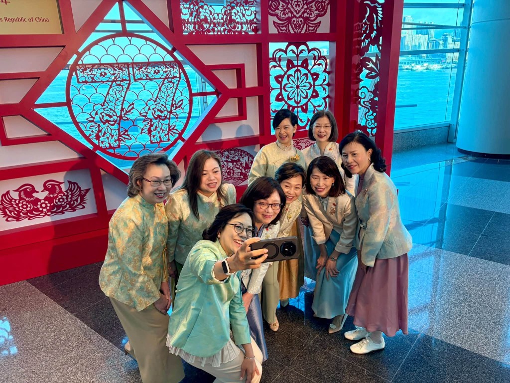 九名女高官身穿華服，在國慶酒會現場自拍，充滿喜悅。