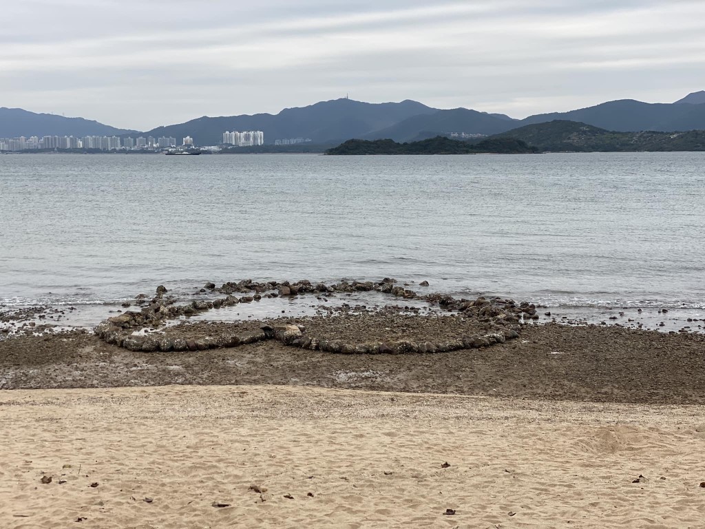 一名中年男子慢慢將大石砌出一個倒心形。fb「烏溪沙石灘海岸關注組」圖片