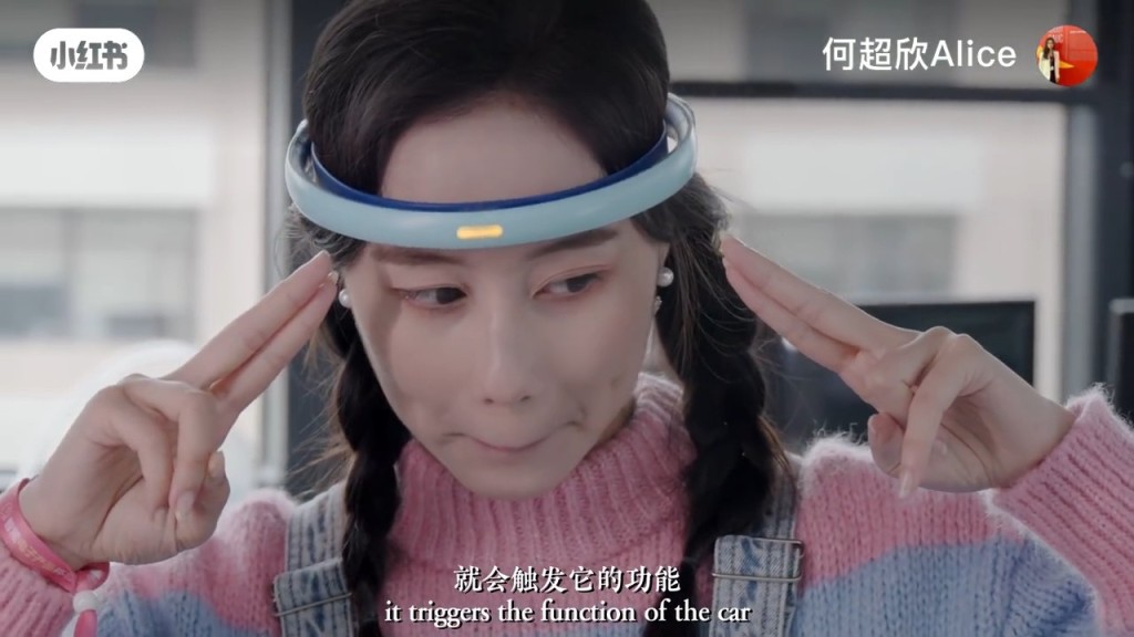 何超欣即席戴上一个粉蓝色的头环，它可测量脑电波来识别使用者的专注力和注意力。