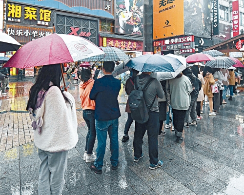 长沙一家奶茶店，数百年轻人冒雨排队。