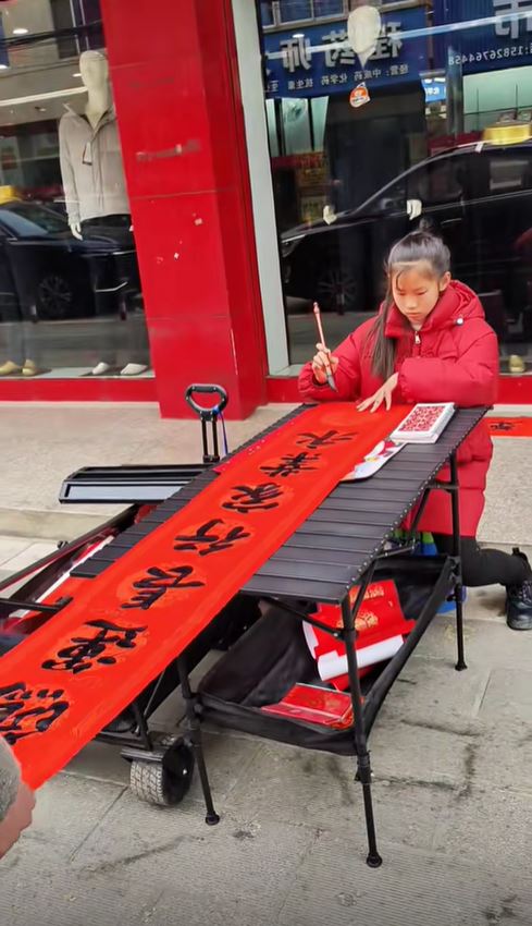 湖北11歲蔣夢涵當街賣手寫春聯，賺錢之餘又可練膽克服「社恐」。