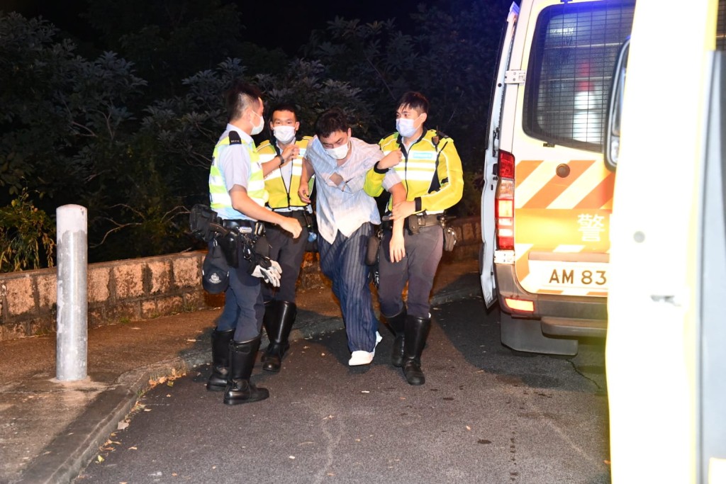 楊明爛醉如泥,由警員扶上救護車。