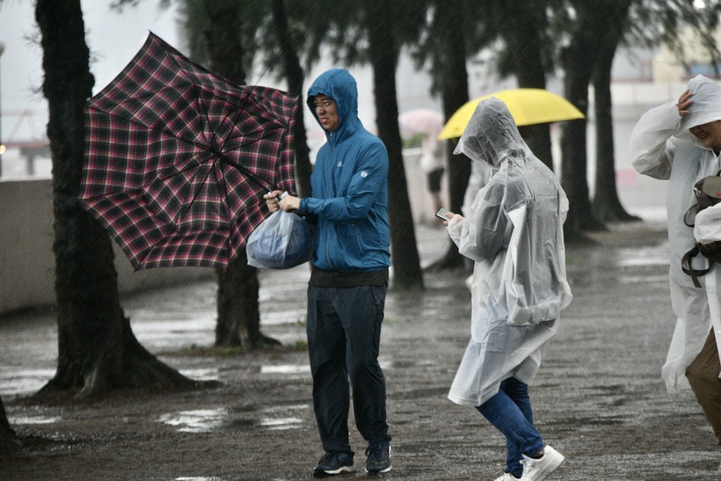 市民雨衣、雨傘一同上陣。盧江球攝