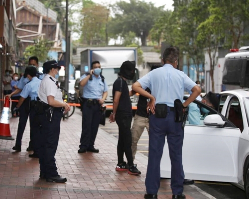警方為被捕男子戴上頭套,其後將他們押往一輛私家車旁調查。