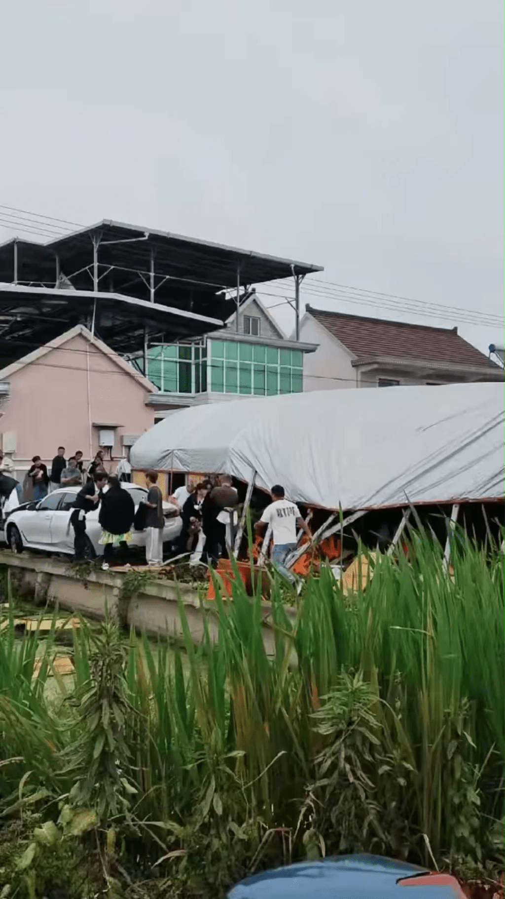 女司機倒車失控，撞入喪禮棚架， 涉事寶馬停河邊。