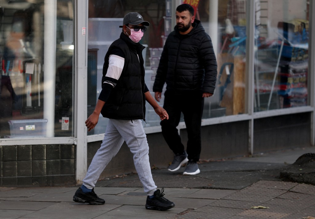 英國流感病例急速攀升，市民戴口罩預防。路透社