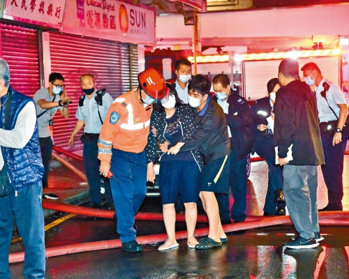■一名女住客吸入濃煙不適,須攙扶到救護車上治理。