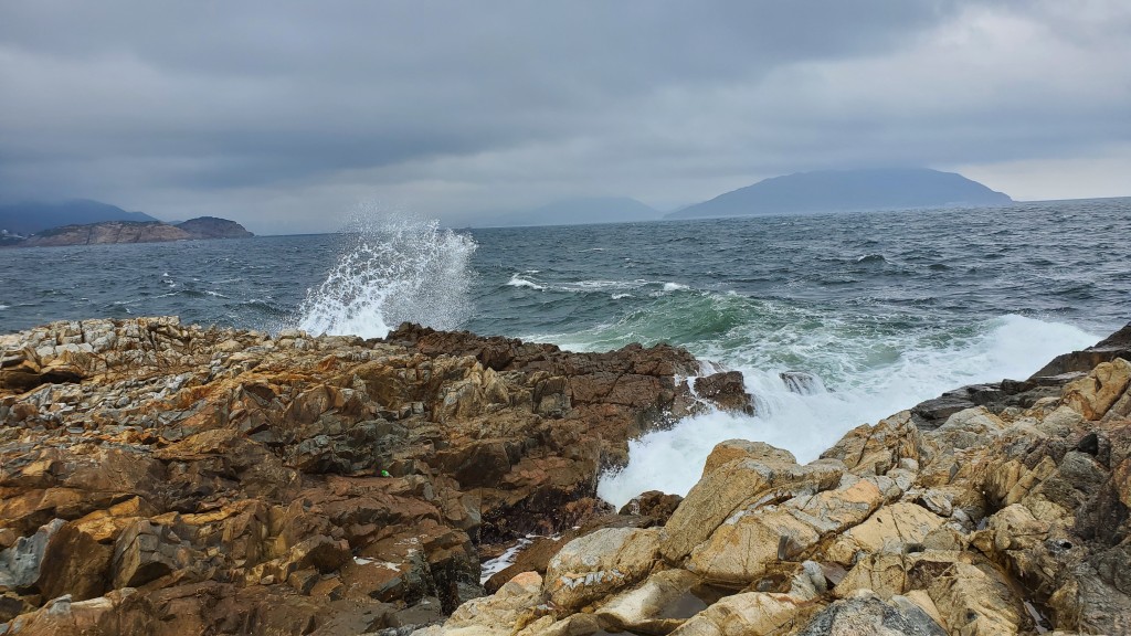 在沿岸不時都有巨浪衝到石頭，濺起高高的浪花。