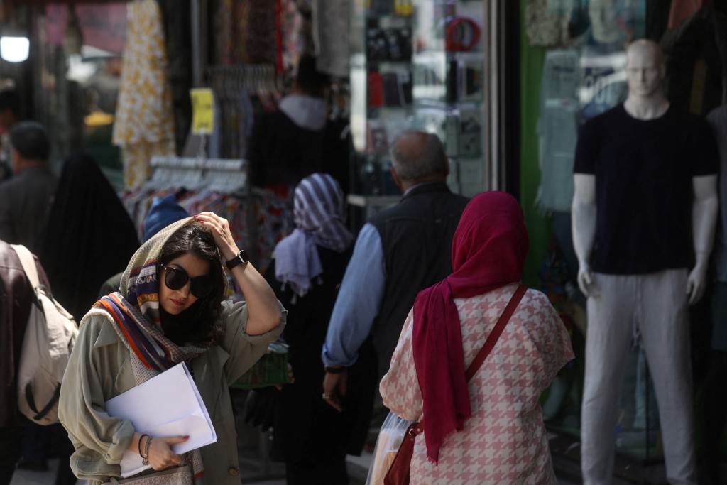 伊朗女性在公共場必須配載頭巾。 路透