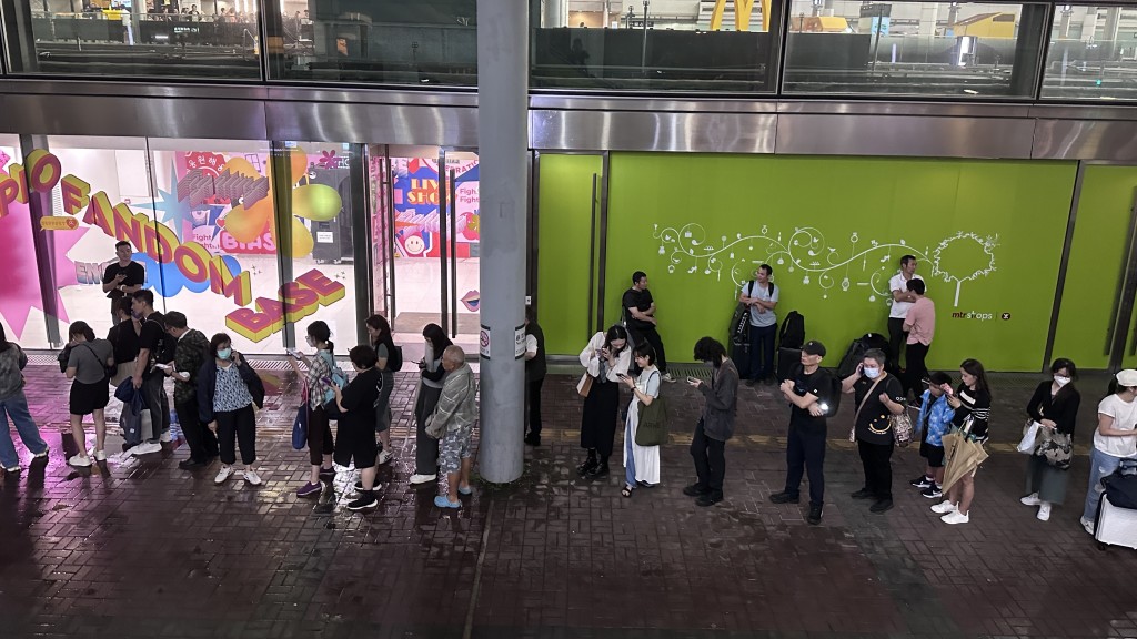颱風小犬吹襲期間市面情況，有市民在鐵路站排長龍等待的士。（蘇正謙攝）