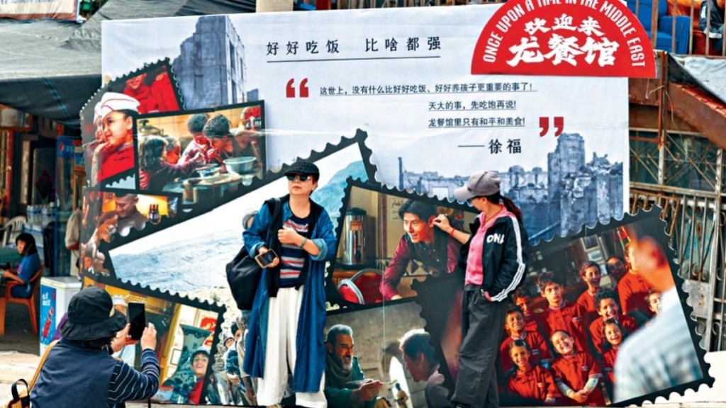 游客在电影布板上拍照。