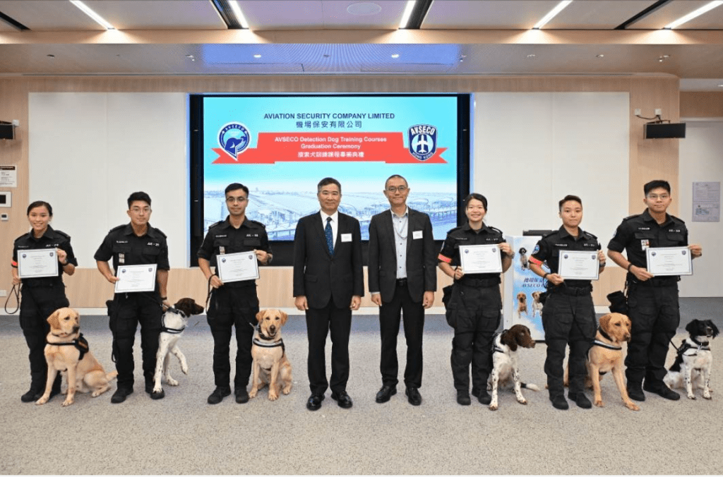 机管局机场运行执行总监姚兆聪(右)、机场保安有限公司行政总裁张德强(左)与六名毕业学员及犬只拍照留念。    