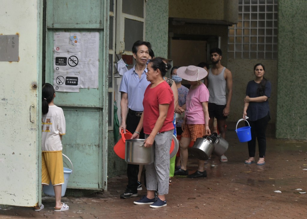 耀東邨居民排隊到樓下取食水。禇樂琪攝