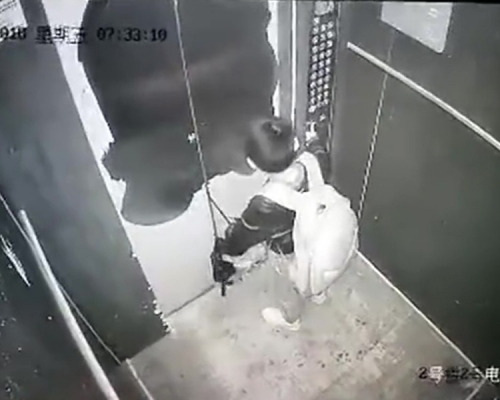 男童将雨伞柄卡住电梯门。(网图)