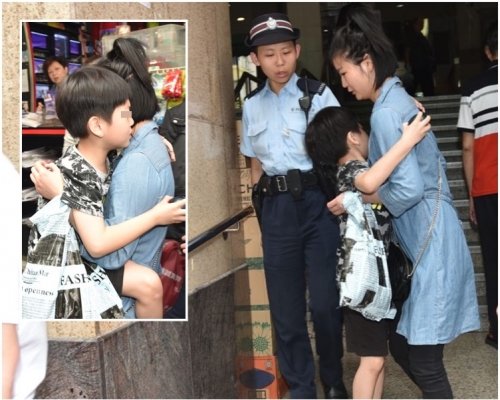 男童由婦人抱上救護車。
