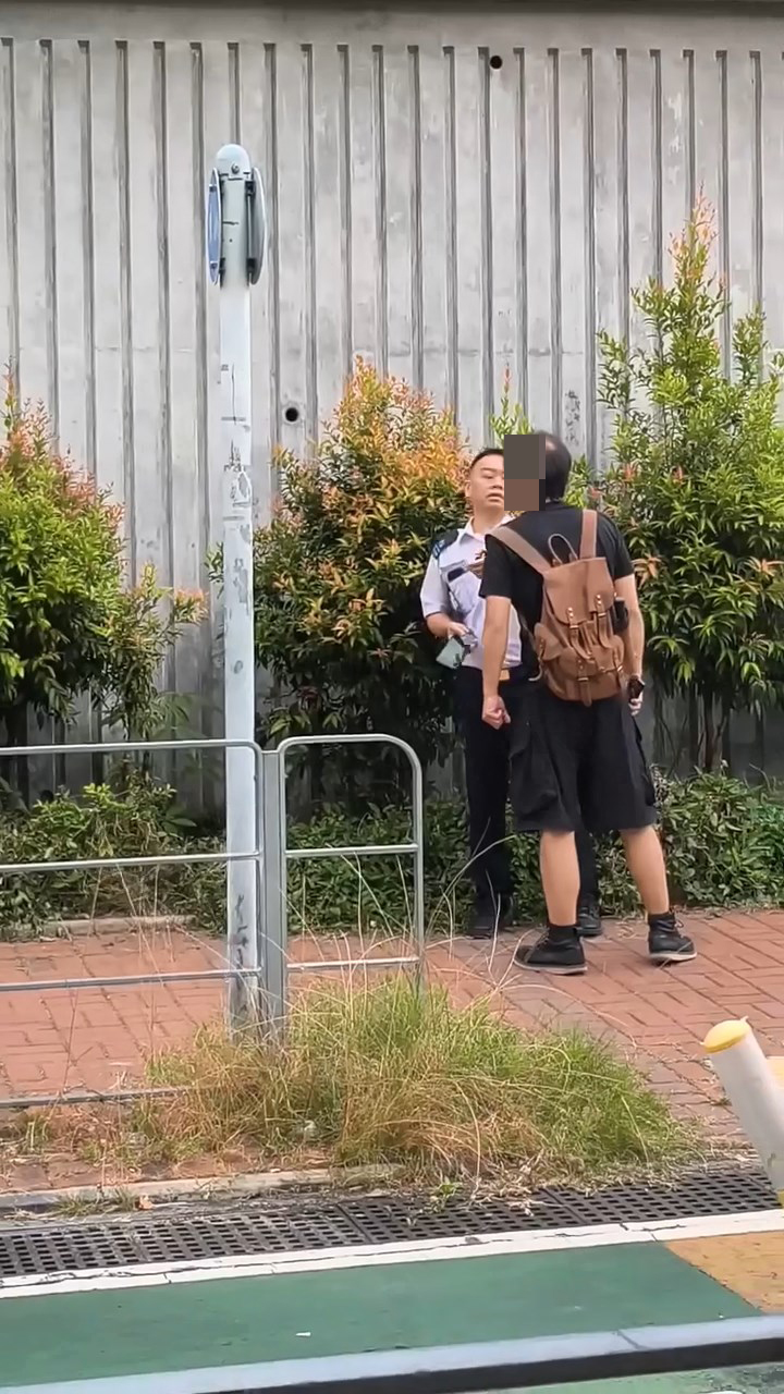 一名身穿黑衣的男子在屯門街頭被食環署人員截查。網上片段截圖 一名身穿黑衣的男子在屯門街頭被食環署人員截查。網上片段截圖