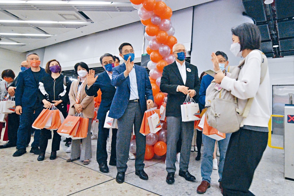 林世雄(右二)及楊潤雄(右四)與港鐵高層出席復運儀式,並向乘客派發紀念品。