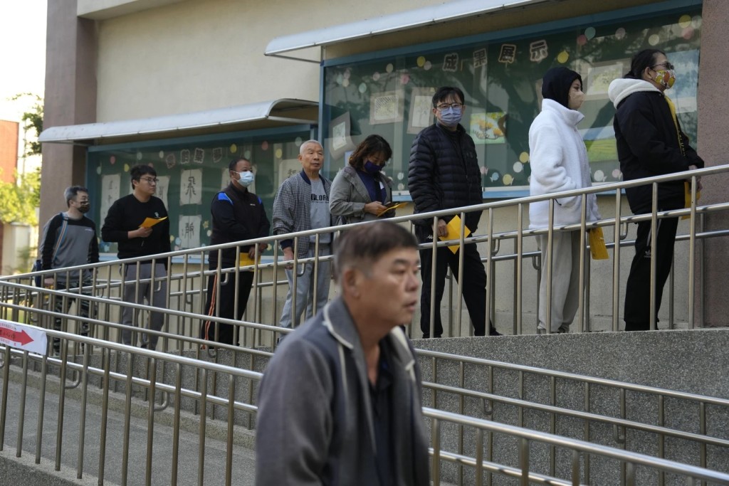 台灣昨日大選，大批選民在票站外等待進入投票。美聯社