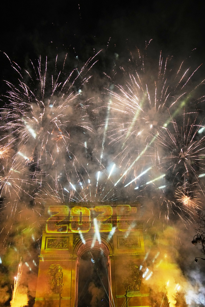 在法國巴黎香榭麗舍大街舉行的新年慶祝活動中，凱旋門上投射出燈光秀，同時煙火綻放。美聯社