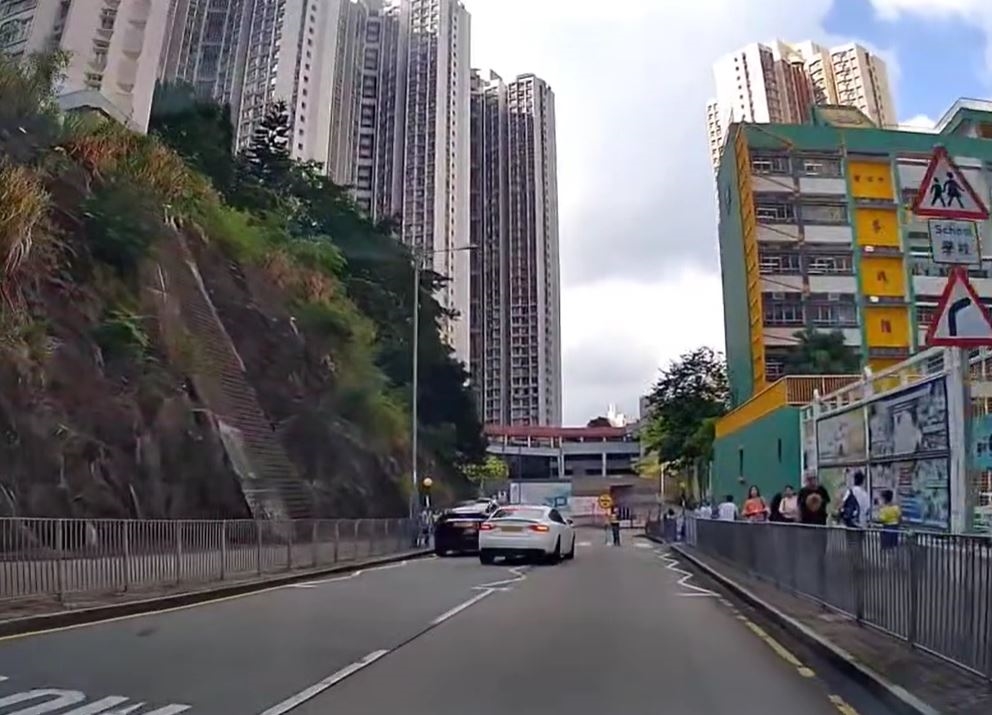 有交通安全隊人員舉牌站在斑馬線上，提示有學童過路。fb車cam L（香港群組）影片截圖