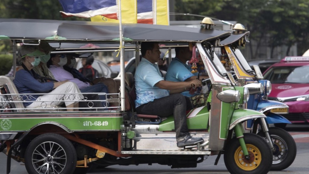 游客在曼谷戴口罩乘搭嘟嘟车。 资料图片