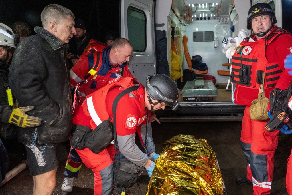 搜救人员移走尸体。美联社