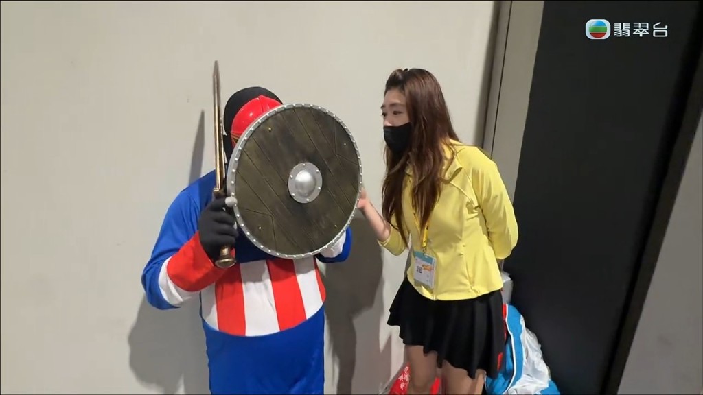 面對主持人的追問，男子起初試圖用手上的道具盾牌遮擋鏡頭拒絕回應。
