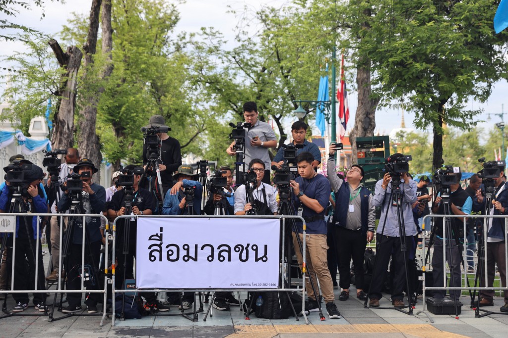 他信回国，大量传媒在曼谷廊曼机场附近等候。路透社