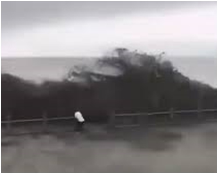 男子走避不及而瞬間被潮水吞沒。影片截圖