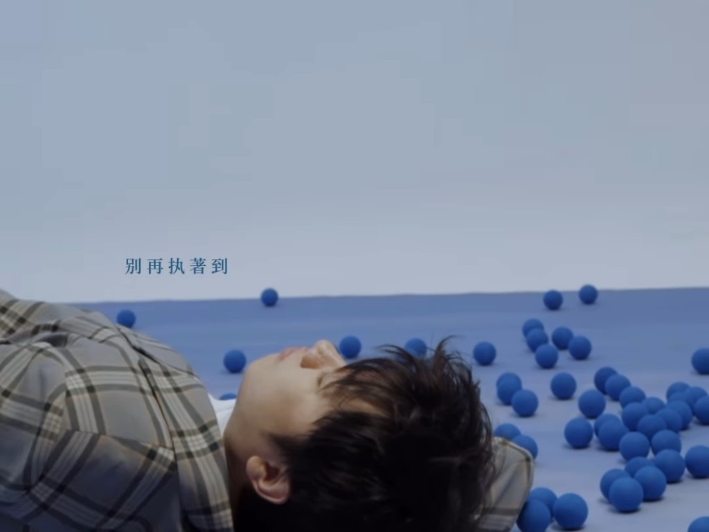 王祖藍躺在地上，身旁有一堆小丑常用的藍色小球。
