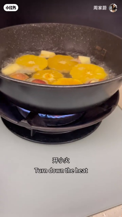 水滾後加入橙片，開小火煮。