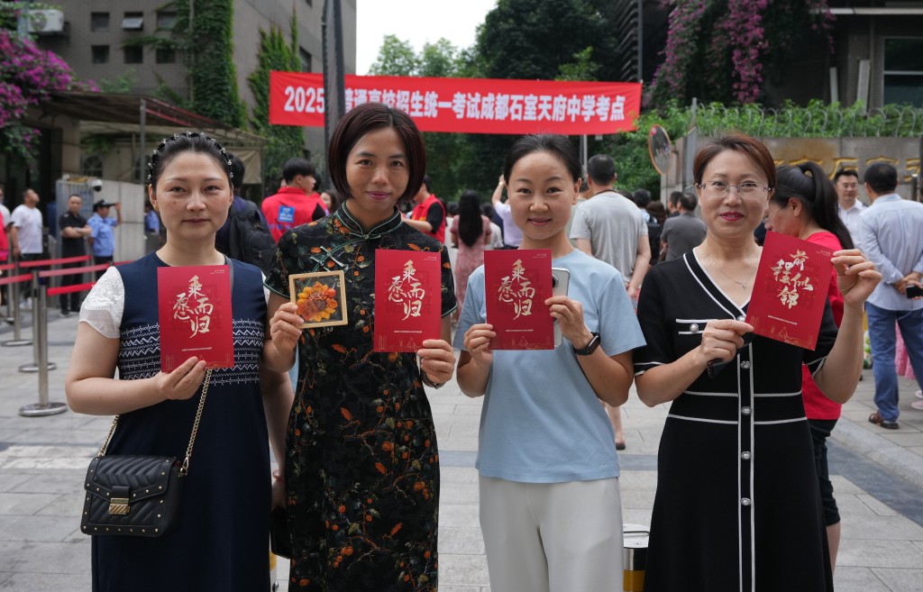 四川成都的家長,穿旗袍手持美好祝願。 中新社 四川成都的家長,穿旗袍手持美好祝願。 中新社
