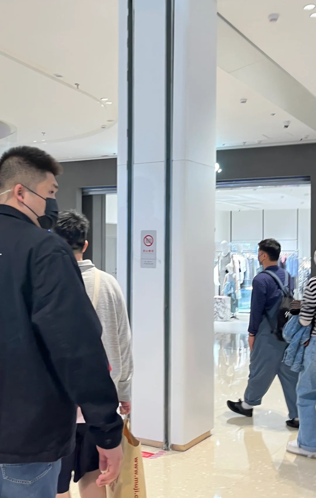 戴上口罩的陳奕迅穿上間條衫、工人褲，走到武漢的大悅城商場逛街。