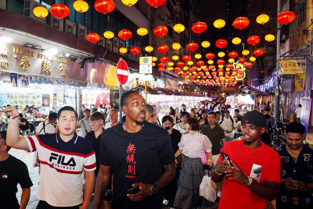  青途副主席唐焯彬（左一）陪同前NBA球星侯活遊廟街。 公關圖片