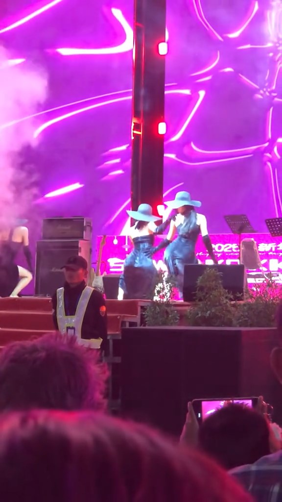 台上有穿上貼身裙女子在音樂扭腰跳舞。