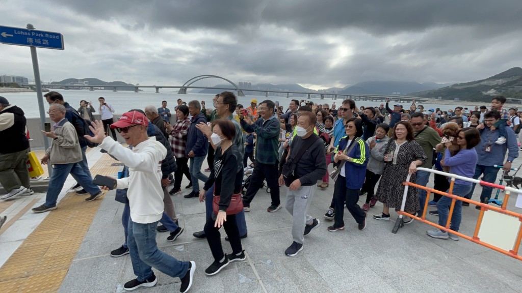 逾百名市民在大橋啟用後，隨即舉起V字手勢衝向拱橋。