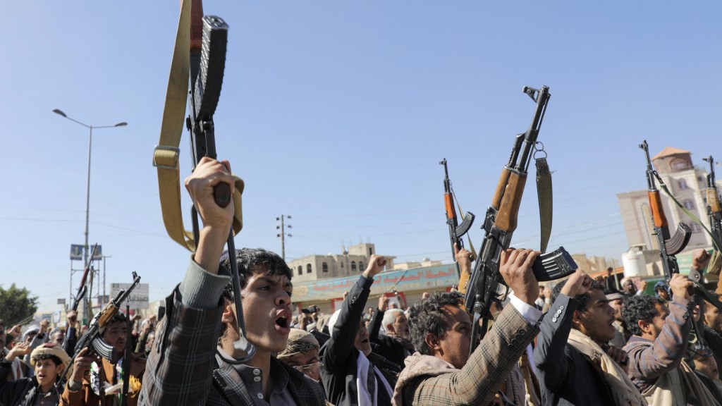 新招募的胡塞武装人员在萨那训练结束后举行的仪式上举起枪支。  路透社